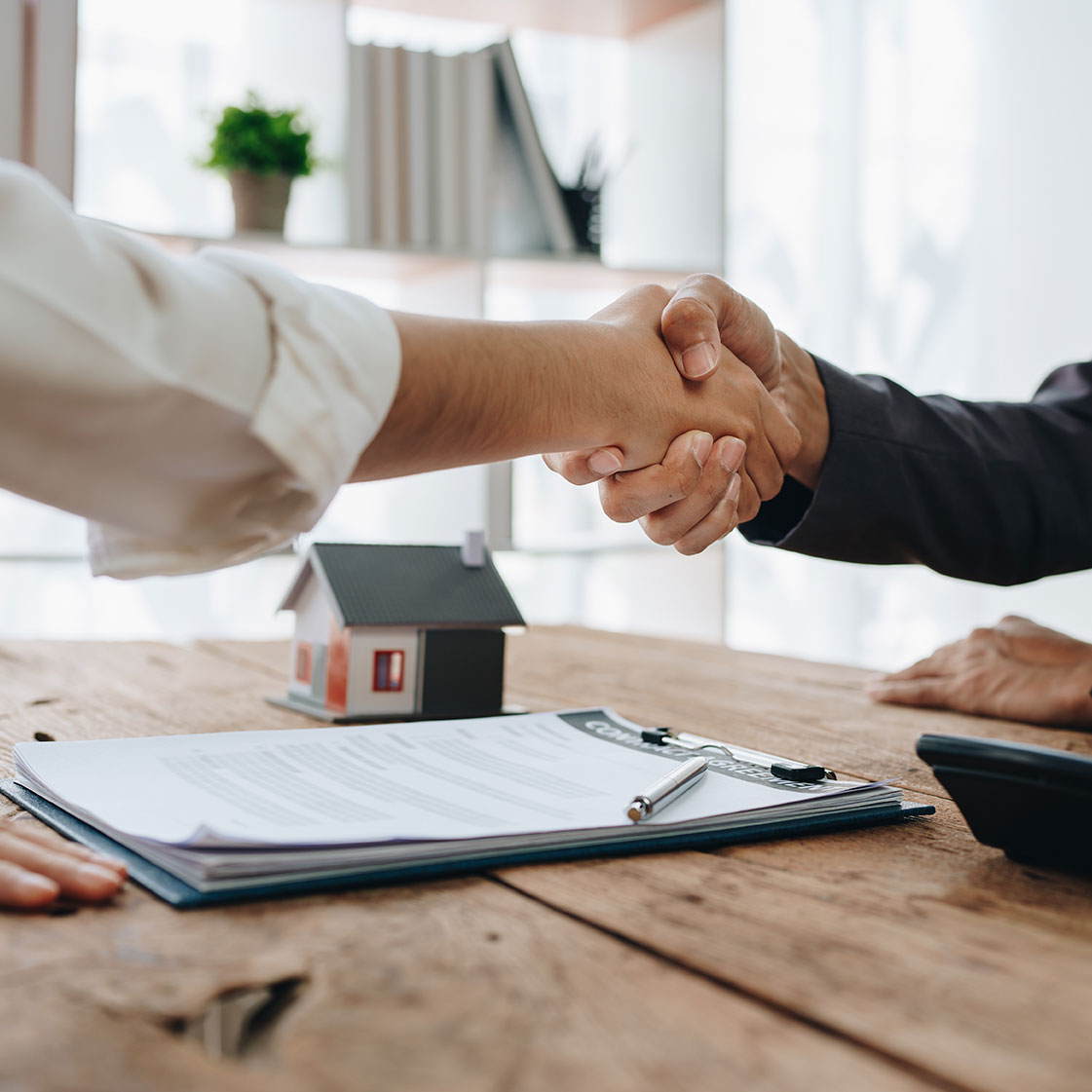 shaking hands over contract on a Desk